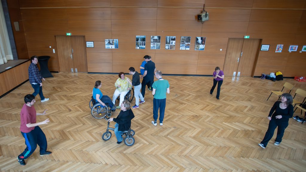 Draufsicht, wie die Tanzenden sich auf ein Zentrum zubewegen